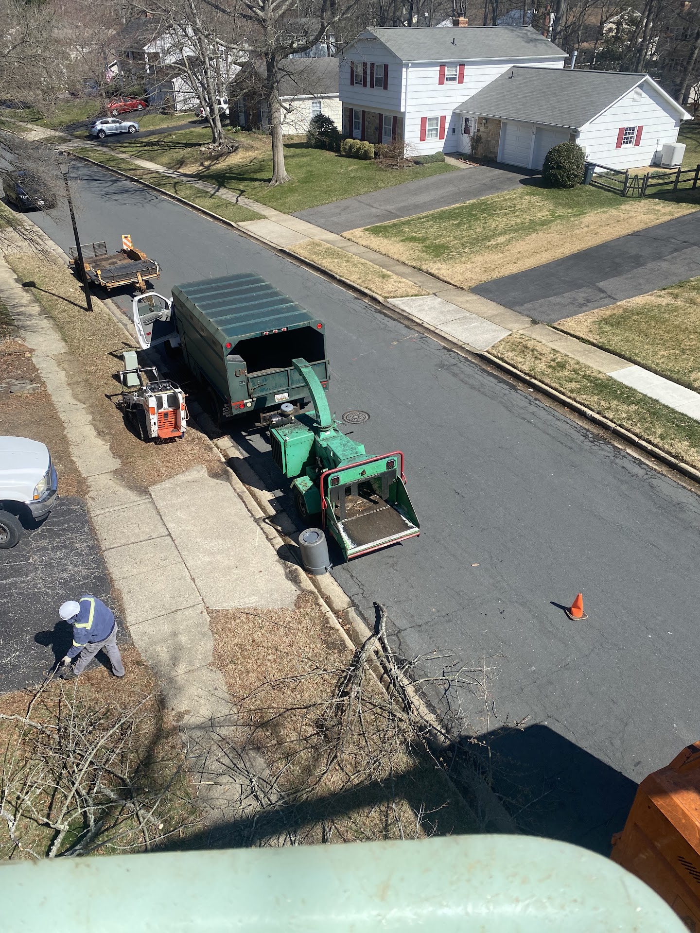 Barton's Tree Care crew and equipment — chip truck, chipper, and stump grinder — working a clearing job on a residential street